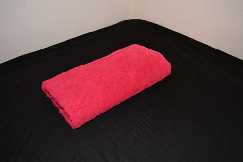 赤いバスタオルでぐるぐる巻きで枕代わり
